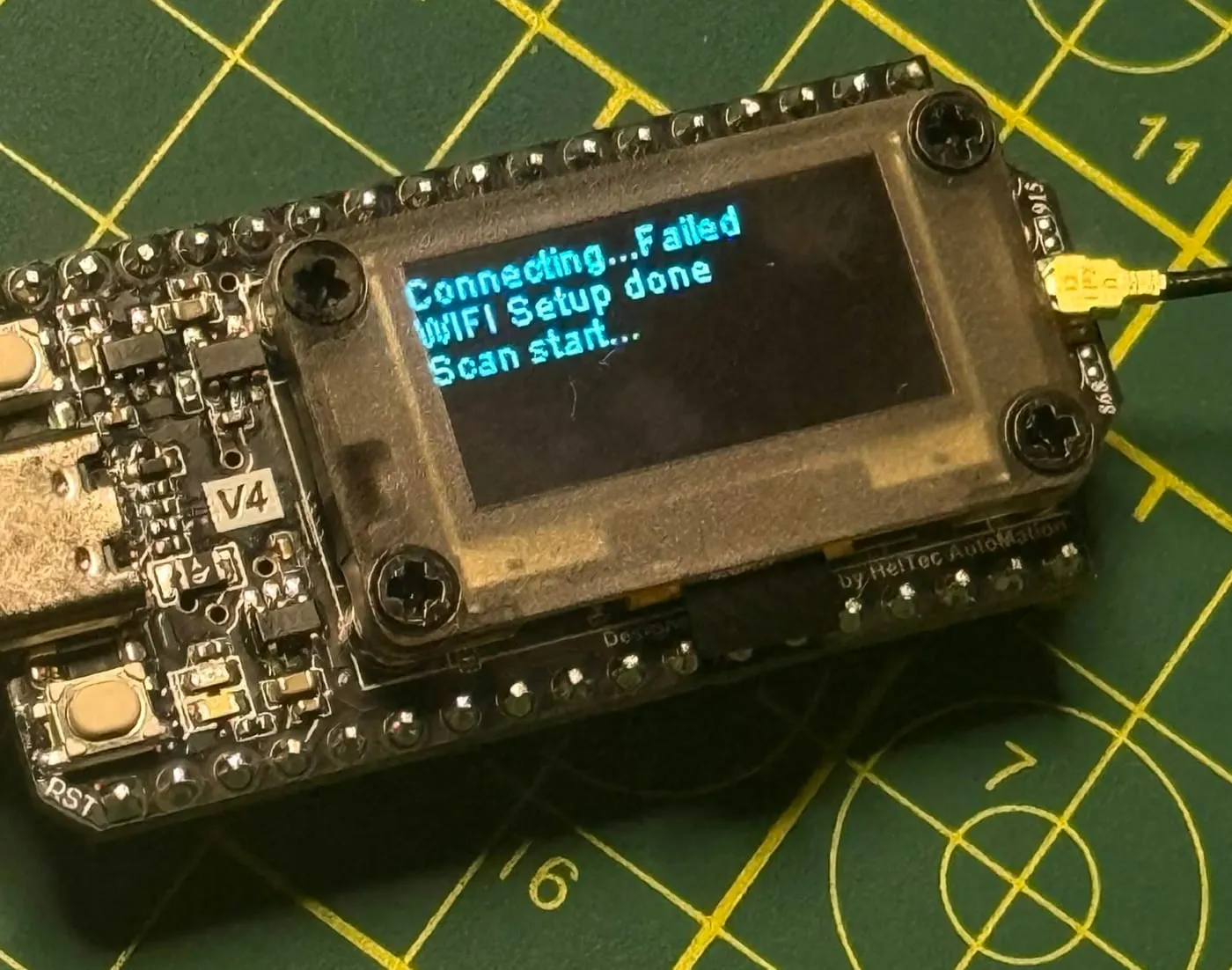 close up of the board's oled reading connecting failed, wifi setup done, scan start